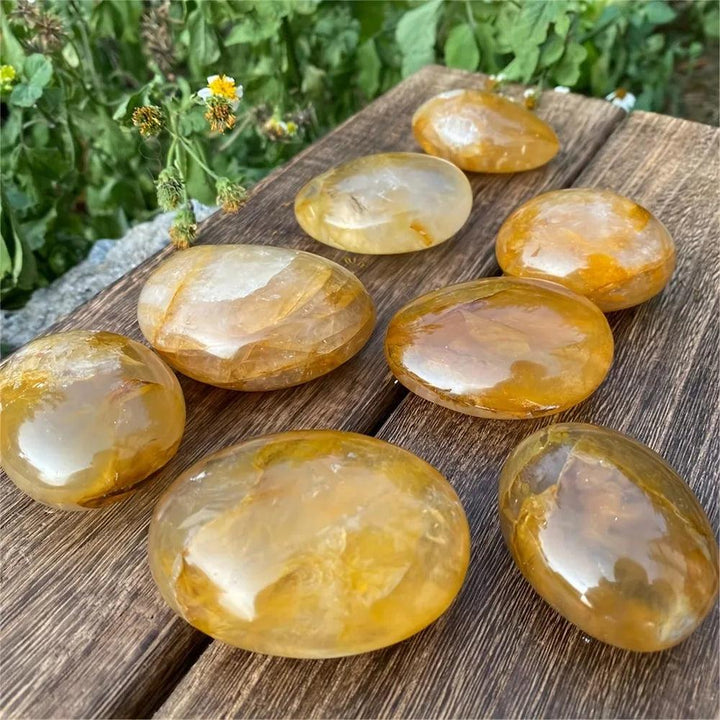 Polished Golden Healer Quartz palm stones with amber iron-rich inclusions, perfect for meditation and healing energy.
