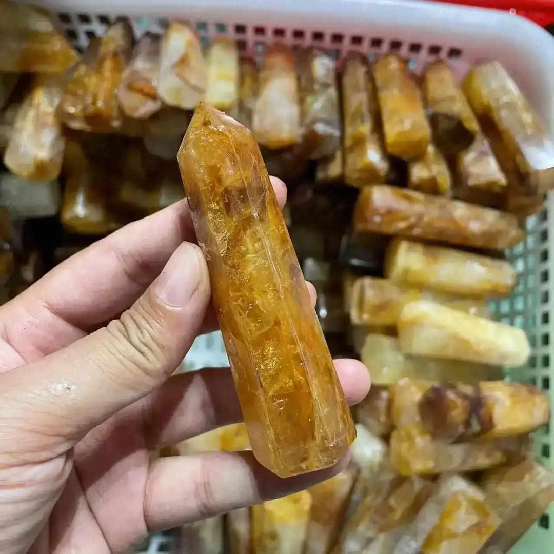 Handheld Golden Healer Quartz obelisk with warm yellow tones, polished to a sharp hexagonal point for uplifting energy.