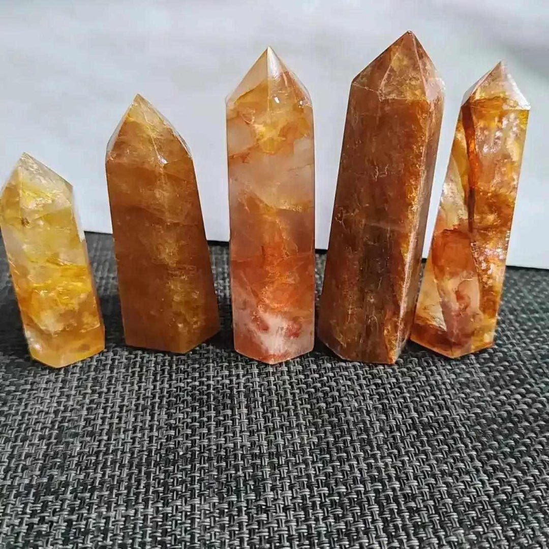 Polished Golden Healer Quartz obelisks with warm yellow iron inclusions, featuring sharp hexagonal points for energy work.