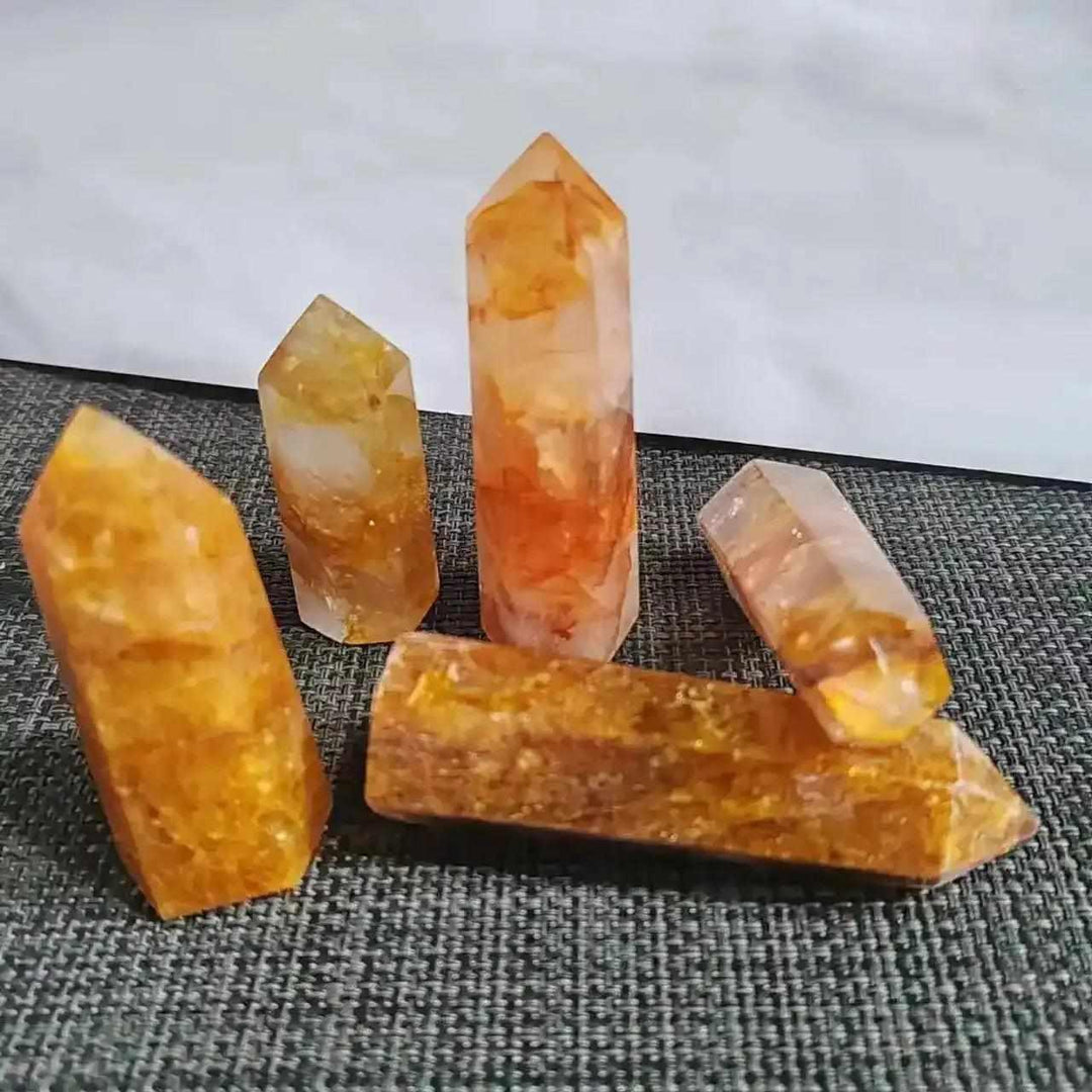 Polished Golden Healer Quartz obelisks with warm yellow iron inclusions, featuring a sharp hexagonal point for energy.