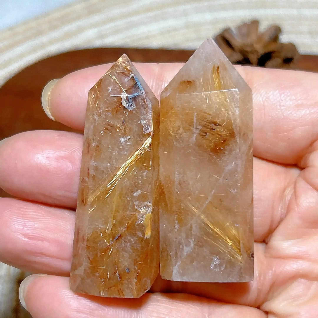 Hand-held Golden Rutilated Quartz towers featuring clear crystal with fine golden rutile needles for amplified energy.