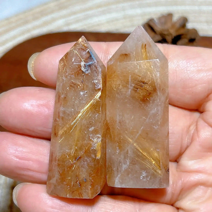 Hand-held Golden Rutilated Quartz towers featuring clear crystal with fine golden rutile needles for amplified energy.