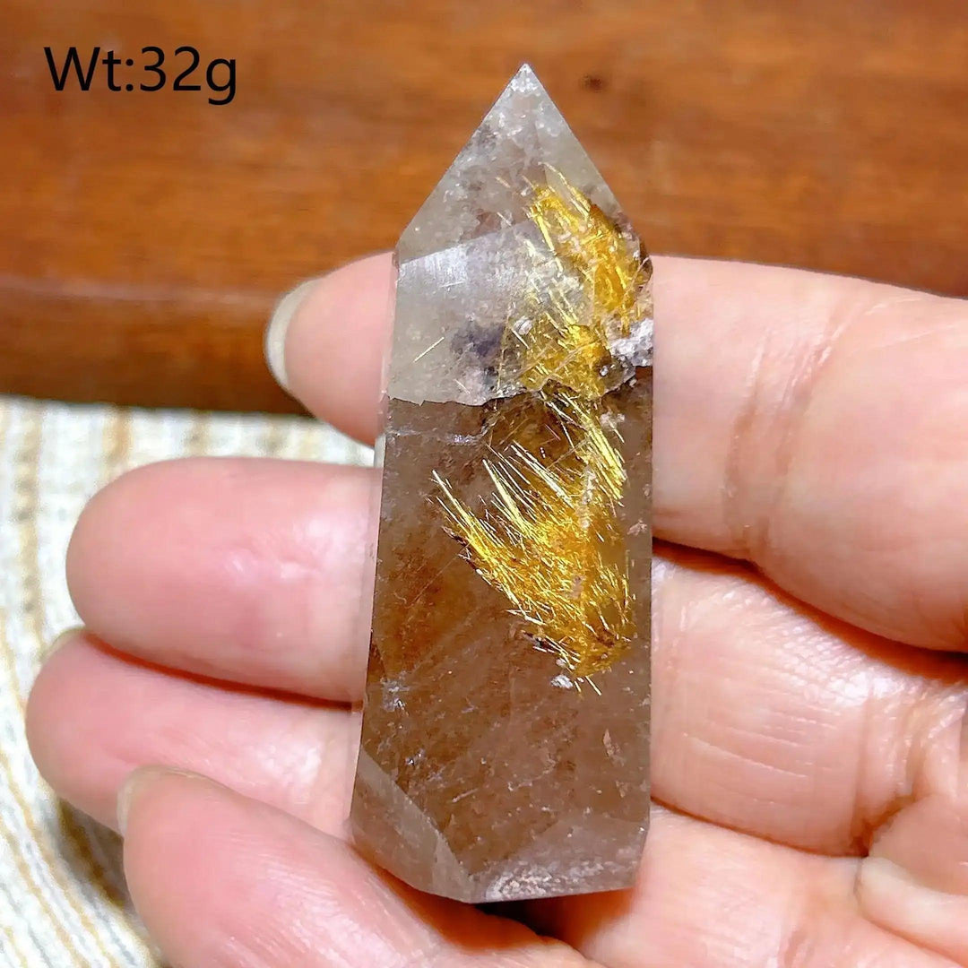 Hand-polished Golden Rutilated Quartz tower featuring clear crystal with vibrant golden rutile needles for energy focus.