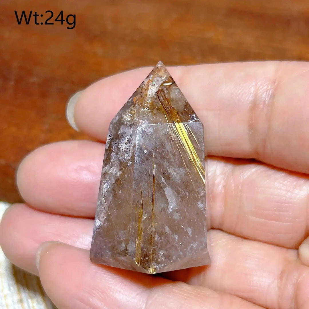 Hand-held Golden Rutilated Quartz tower featuring clear crystal with fine golden rutile needles for amplified energy.