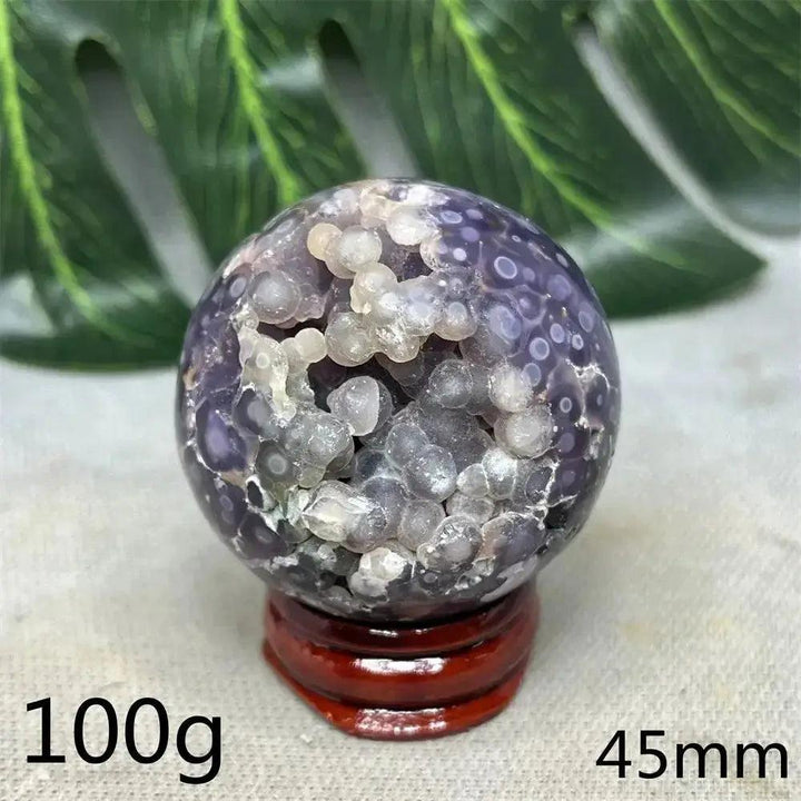 Indonesian Grape Agate Crystal Sphere: Polished orb with shimmering lilac, lavender, and deep purple botryoidal formations.