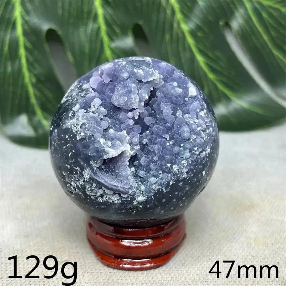 Indonesian Grape Agate Crystal Sphere: Lilac, lavender, deep purple botryoidal formations, polished orb on a wood stand. Soothing energy.