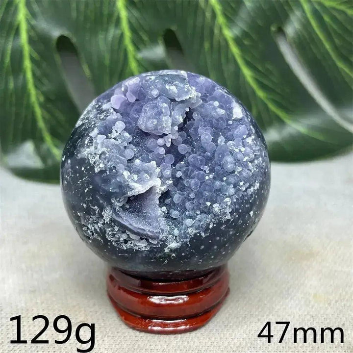Indonesian Grape Agate Crystal Sphere: Lilac, lavender, deep purple botryoidal formations, polished orb on a wood stand. Soothing energy.