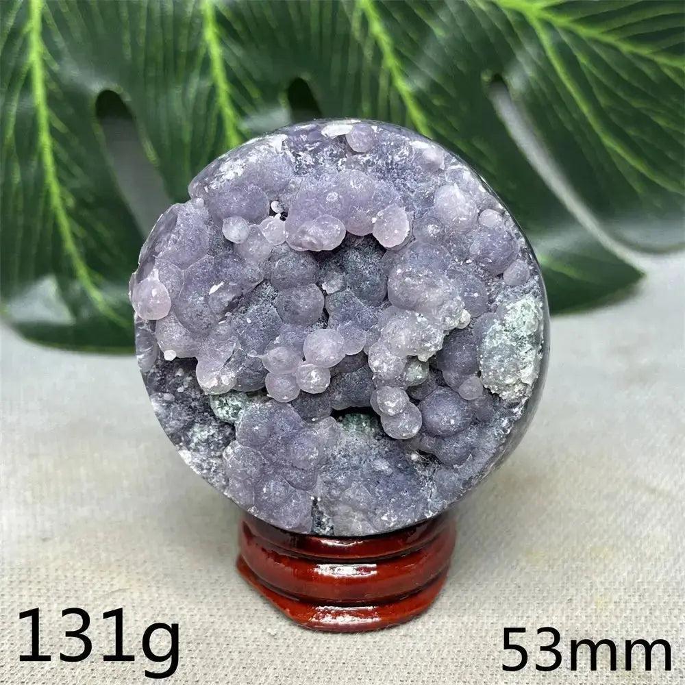 Indonesian Grape Agate Crystal Sphere: Lilac, lavender, deep purple botryoidal formations, polished orb on a wooden stand. Soothing energy.