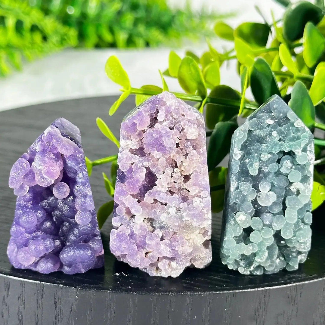 Three polished Grape Agate towers from Crystal Destiny in purple, lavender, and teal, with botryoidal formations.