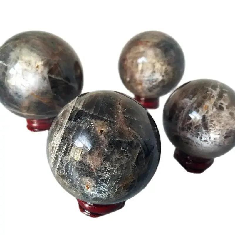 Four Gray Moonstone crystal spheres from Crystal Destiny, showcasing silvery-gray shimmer and adularescence.