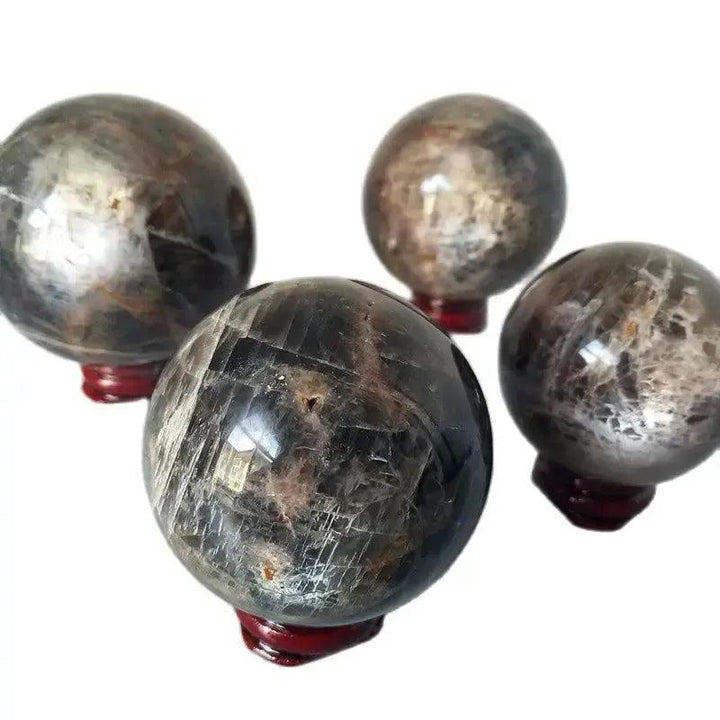 Four Gray Moonstone crystal spheres from Crystal Destiny, showcasing silvery-gray shimmer and adularescence.