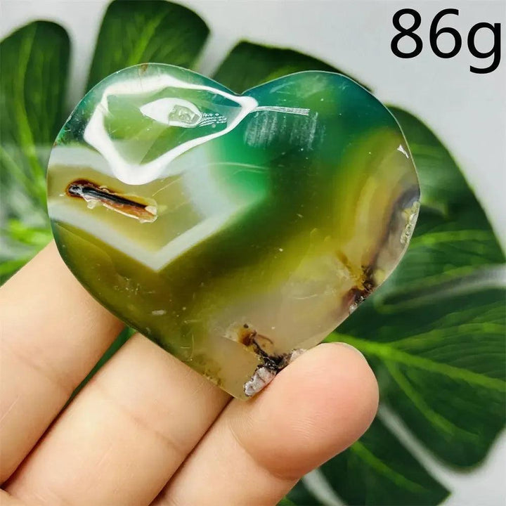 Hand-carved Green Agate Crystal Heart with natural green banding, promoting growth, abundance, and emotional balance.