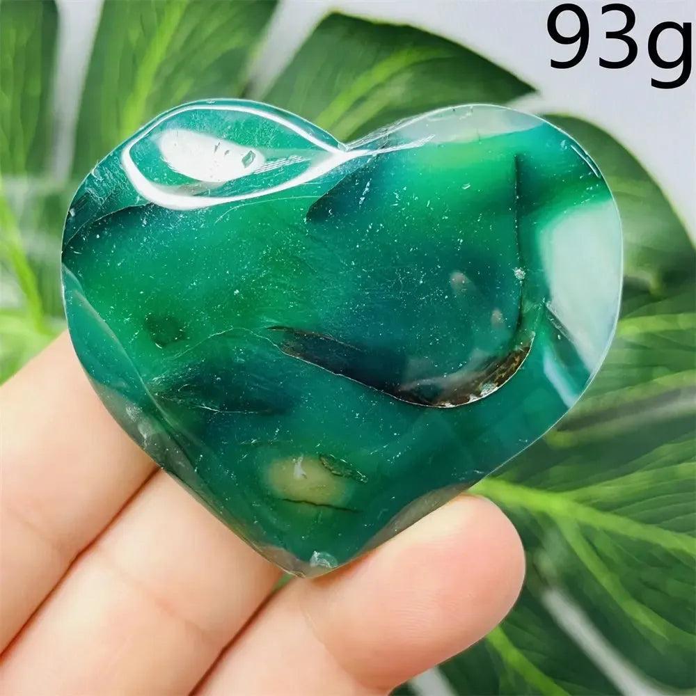 Hand-carved Green Agate Crystal Heart with natural green banding, promoting growth, abundance, and emotional balance.