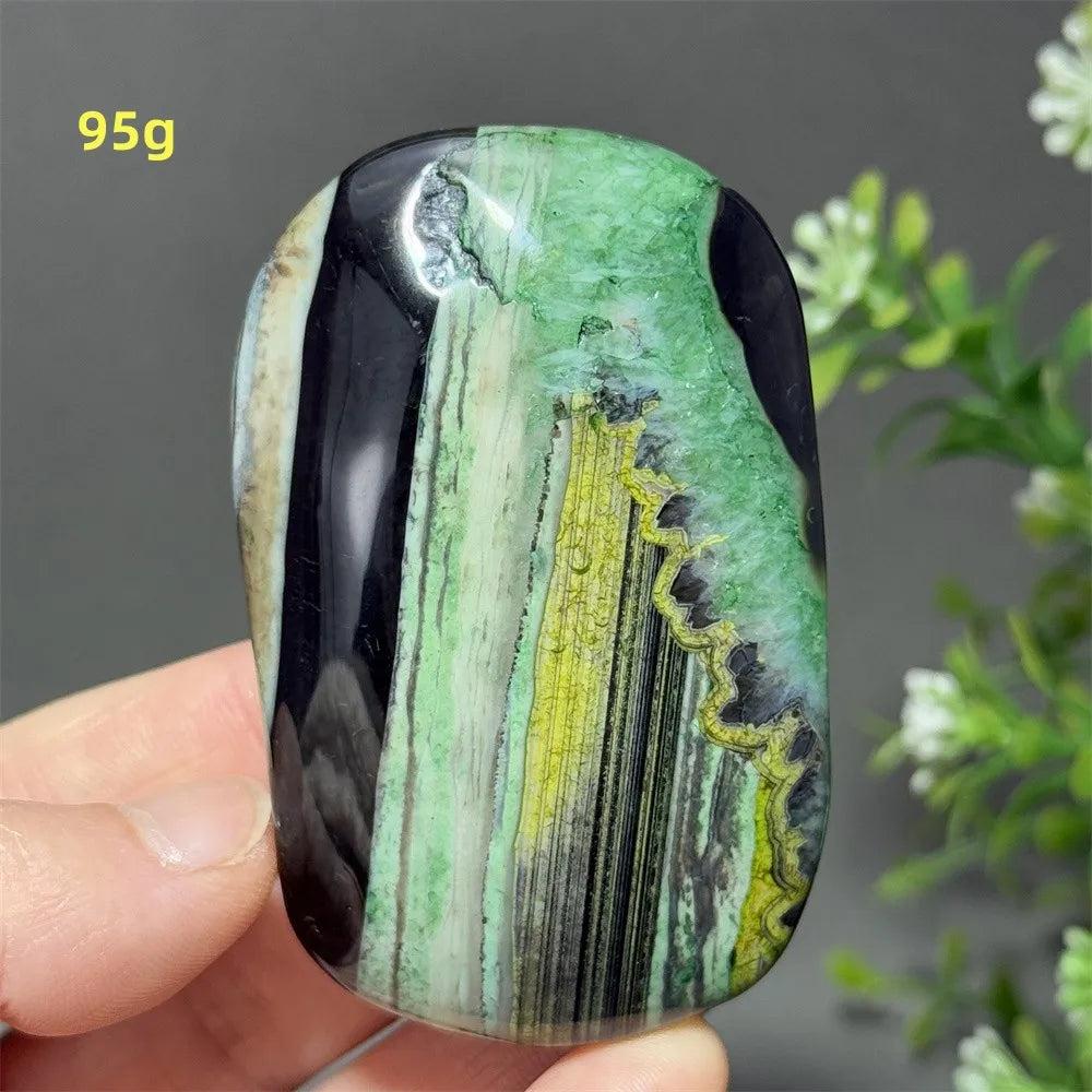 Polished 95g natural green agate palm stone featuring vibrant green, black, and yellow banding for healing and meditation.