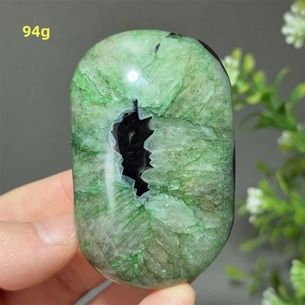 Polished 94g natural green agate palm stone with a unique dark center, perfect for reiki, meditation, and healing.