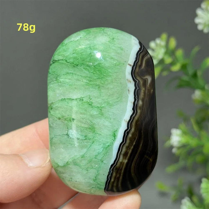 Polished 78g natural green agate palm stone with unique black banding for reiki, meditation, and spiritual healing.