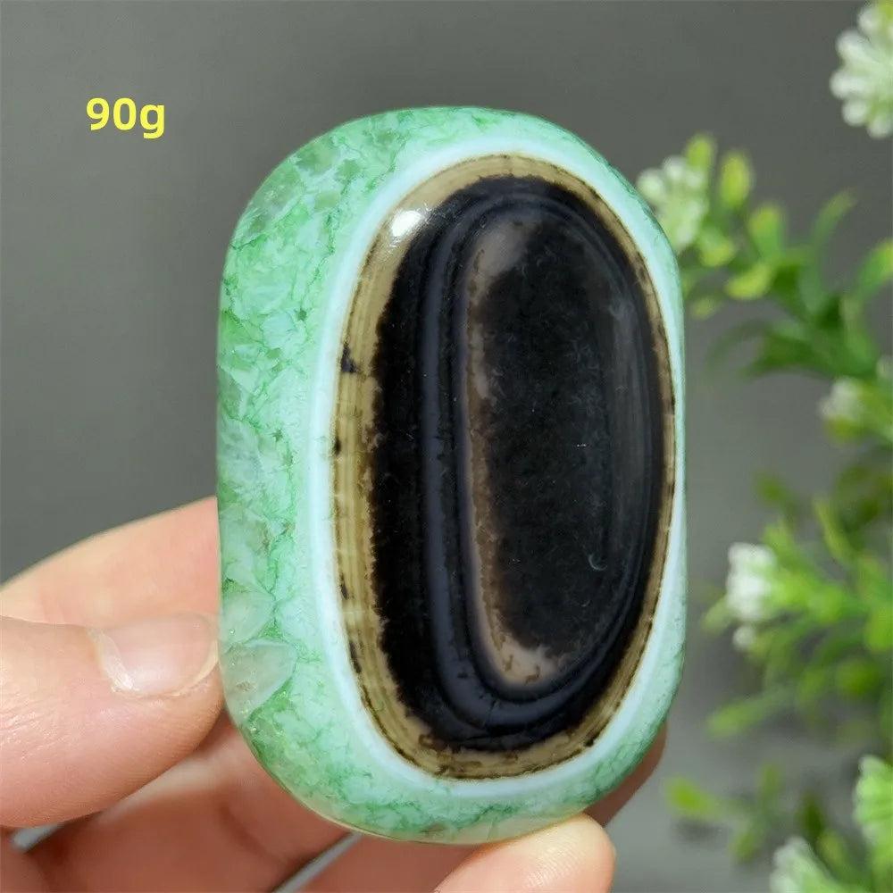 90g polished natural green agate palm stone with a striking black center, perfect for meditation and spiritual healing.