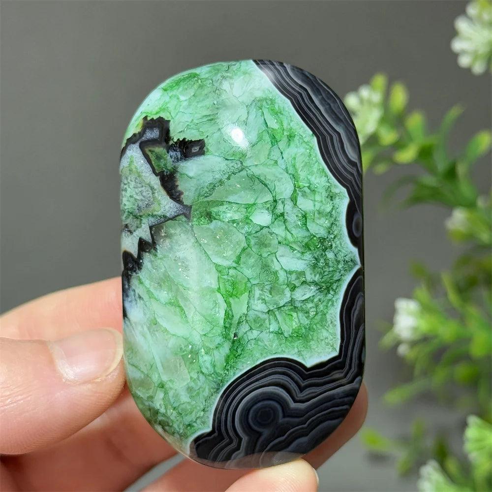 Polished natural green agate palm stone with striking black banding, perfect for healing, meditation, and decor.