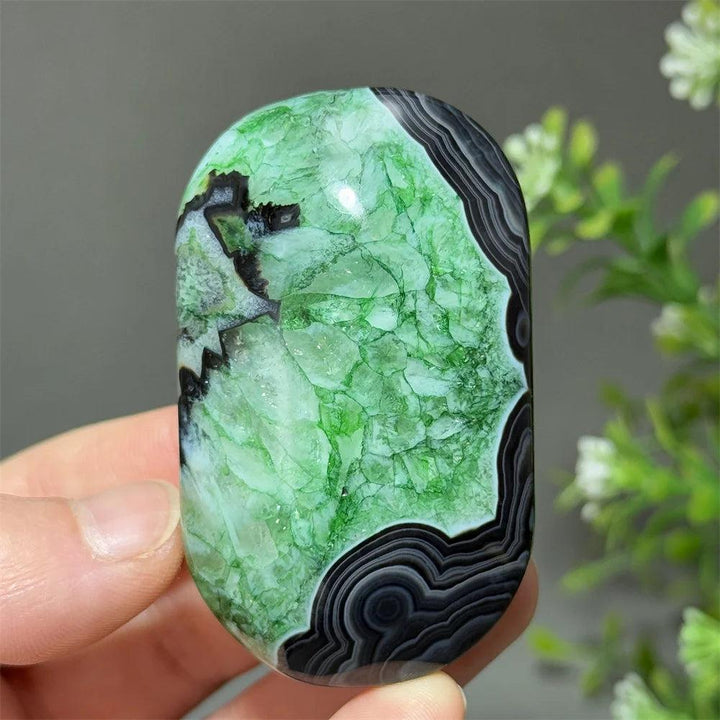 Polished natural green agate palm stone with striking black banding, perfect for healing, meditation, and decor.