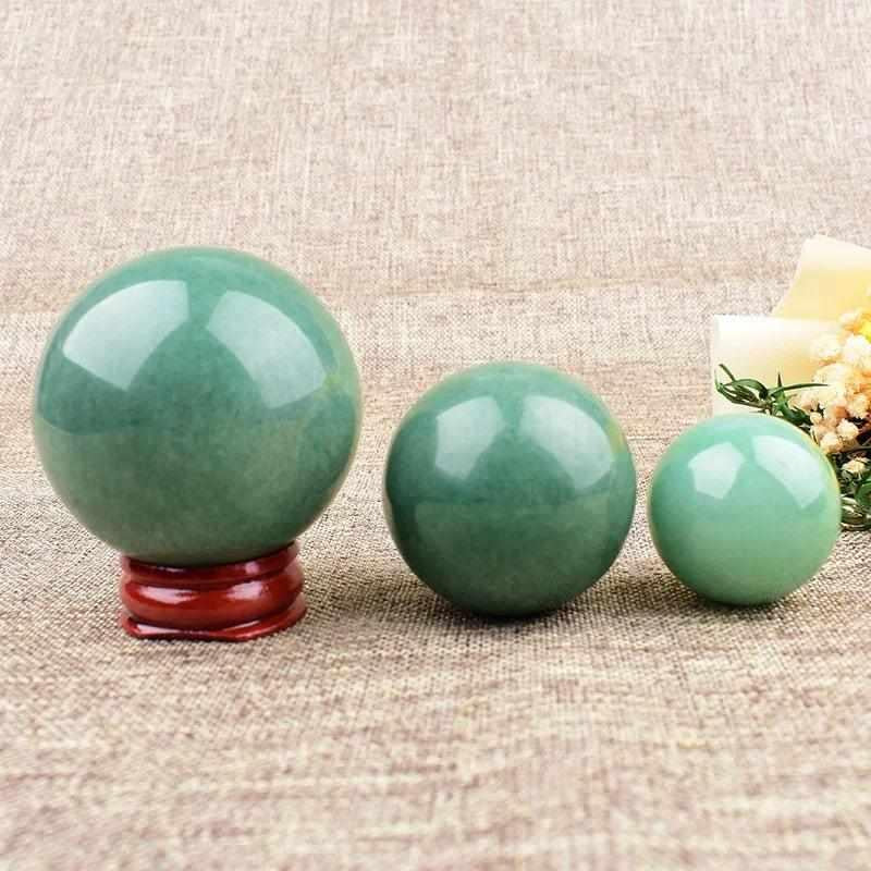 Polished green aventurine spheres in three sizes, showcasing natural shimmer and heart chakra healing energy.