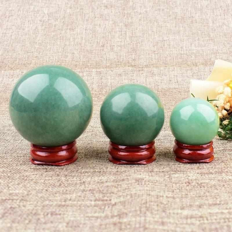 Polished green aventurine spheres in three sizes, showcasing natural shimmer and heart chakra healing energy.