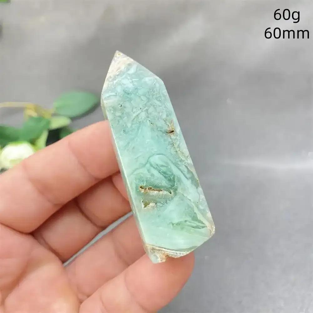 Hand-polished Green Calcite tower with soft green banding and a faceted point for Heart chakra meditation and renewal.