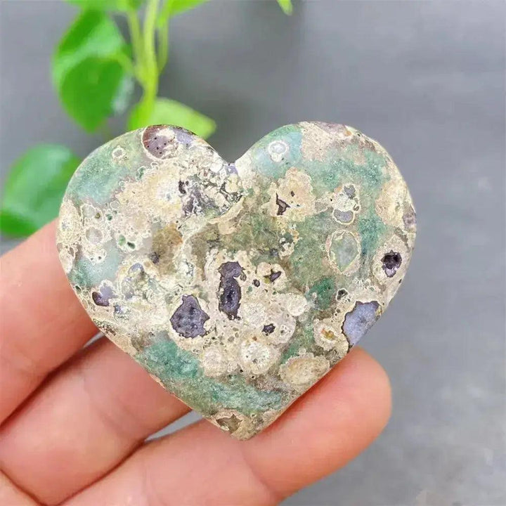 Green Cherry Agate Heart Crystal: smooth, heart-shaped stone with soft green tones and cherry-like inclusions, promoting emotional balance.