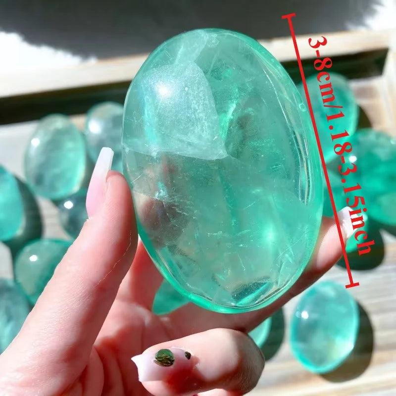 Polished clear green fluorite palm stone, a soothing natural crystal gift for healing and decor.