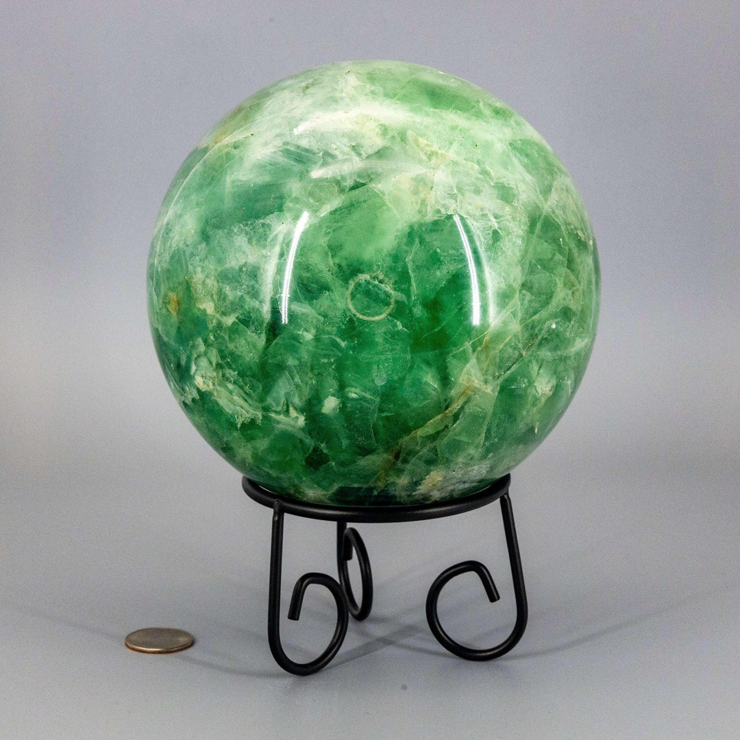 Collector-grade 153mm Green Fluorite Sphere crystal ball, displaying deep forest to pale celadon hues on a black stand.