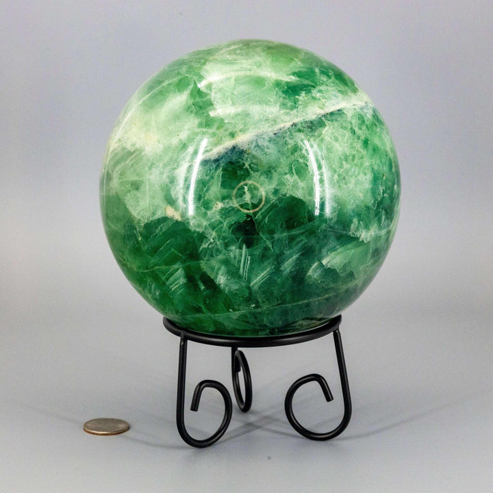 Collector-grade 153mm Green Fluorite Sphere with celadon to deep forest green hues on a black stand.