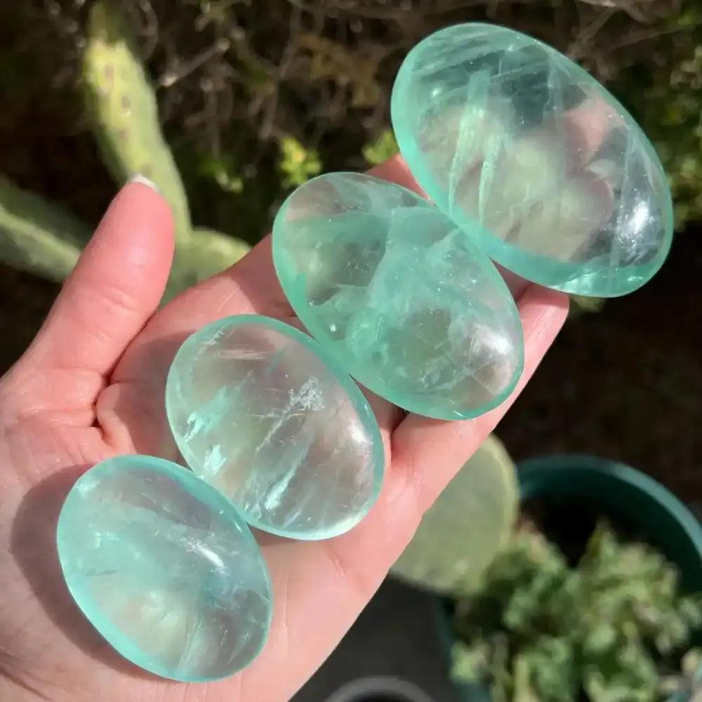 Polished natural green fluorite palm stones with translucent clarity, perfect for healing, meditation, and home decor.