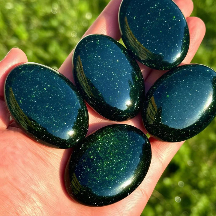 Polished green sandstone palm stones with sparkling gold flecks for meditation and luck.