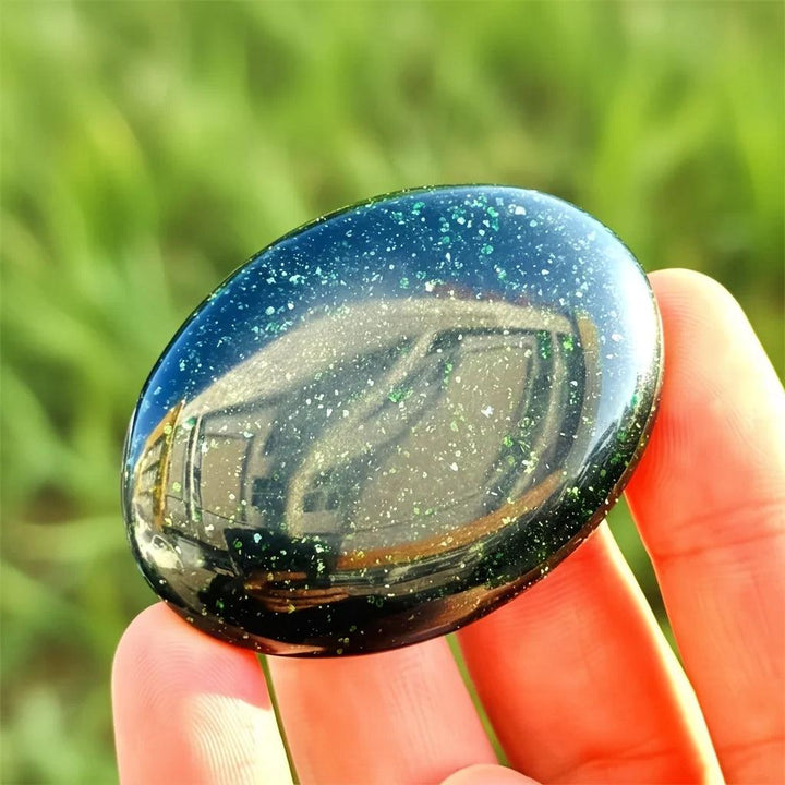 Polished green sandstone palm stone with sparkling metallic flecks for meditation and luck.