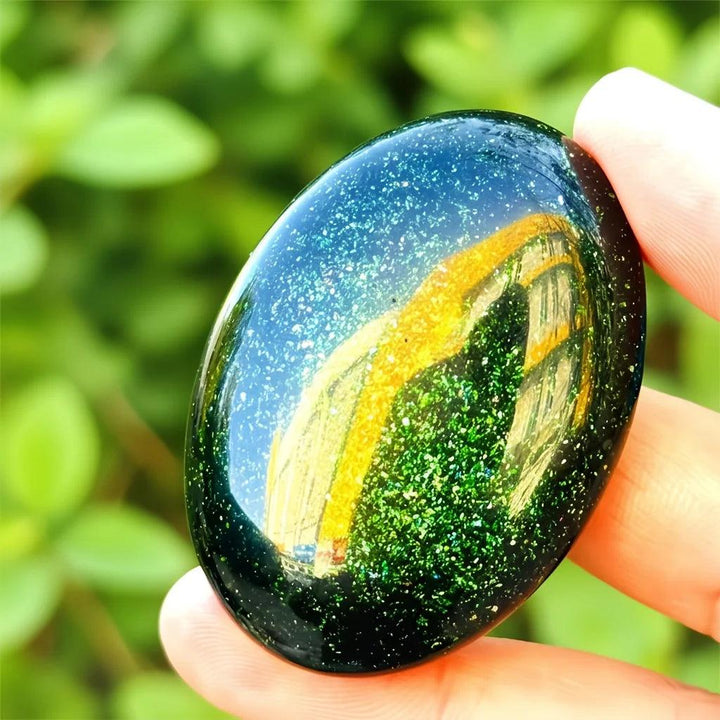 Polished green sandstone palm stone with sparkling gold and green flecks for meditation and luck.