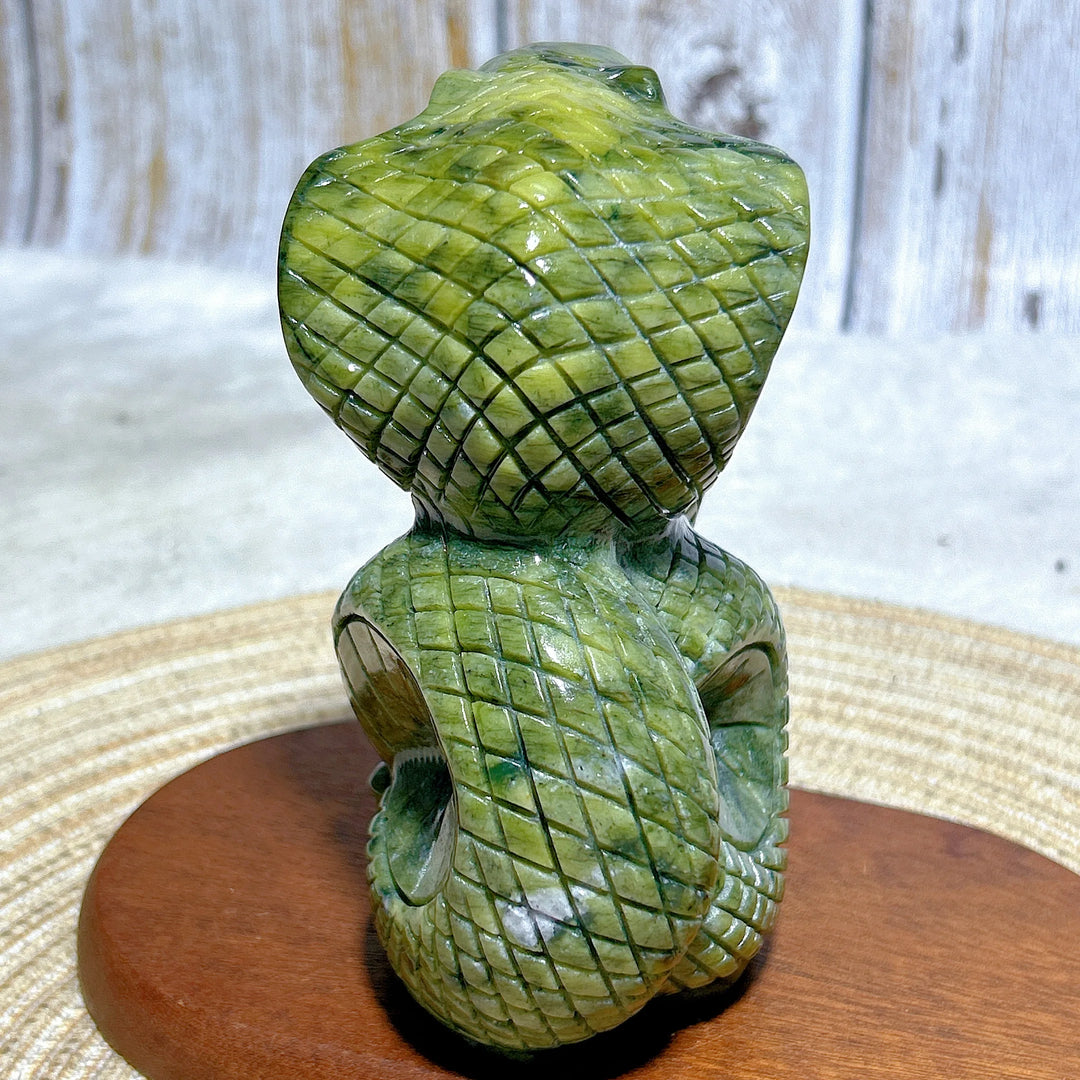 Green jasper cobra carving with intricate scale details, a grounding stone for heart and root chakra meditation.