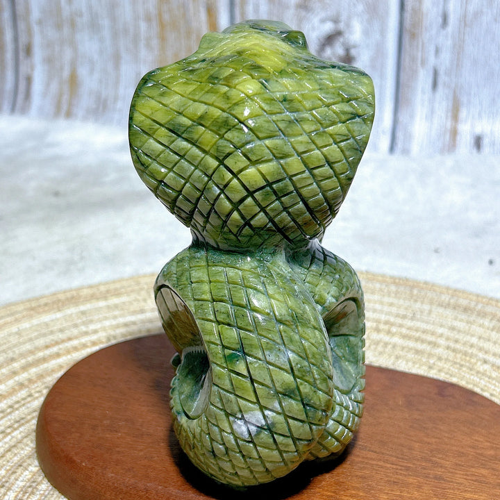 Green jasper cobra carving with intricate scale details, a grounding stone for heart and root chakra meditation.