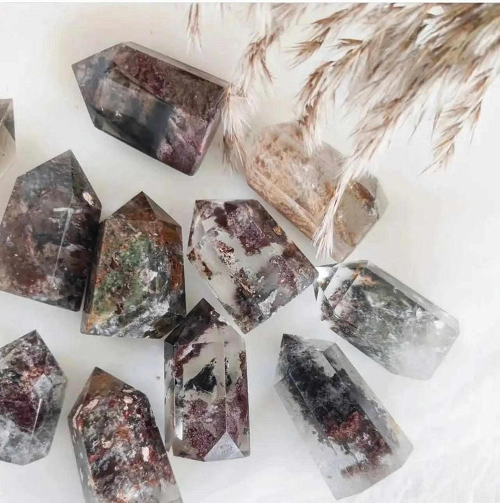 Handheld Green Phantom Garden Quartz points featuring mossy inclusions and clear crystal towers for healing grids.