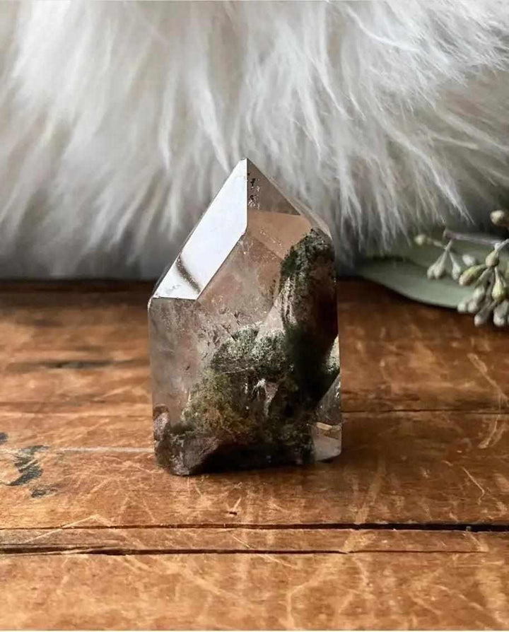 Green Phantom Garden Quartz point featuring mossy inclusions and ghostly phantoms for heart chakra healing and growth.