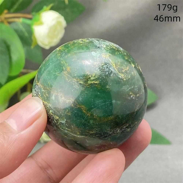Polished 46mm Green Verdite sphere with deep green tones and grounding energy, held in hand for heart chakra healing.