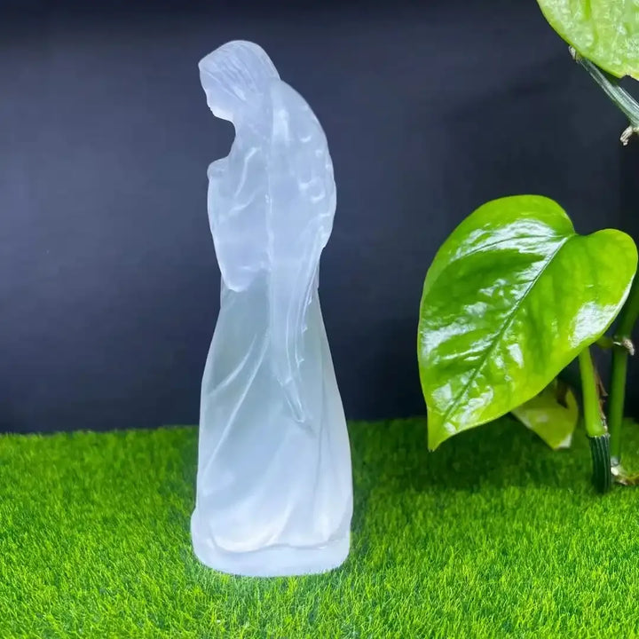 Hand carved white selenite guardian angel figurine, a translucent healing crystal stone for peaceful home decor.
