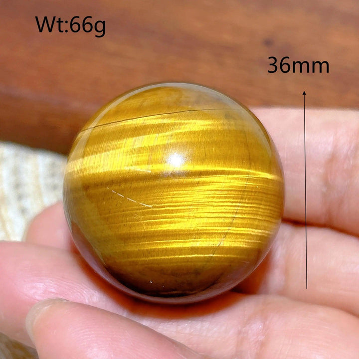 36mm natural yellow Tiger Eye crystal sphere, a polished 66g healing stone ball with vibrant golden chatoyant luster.