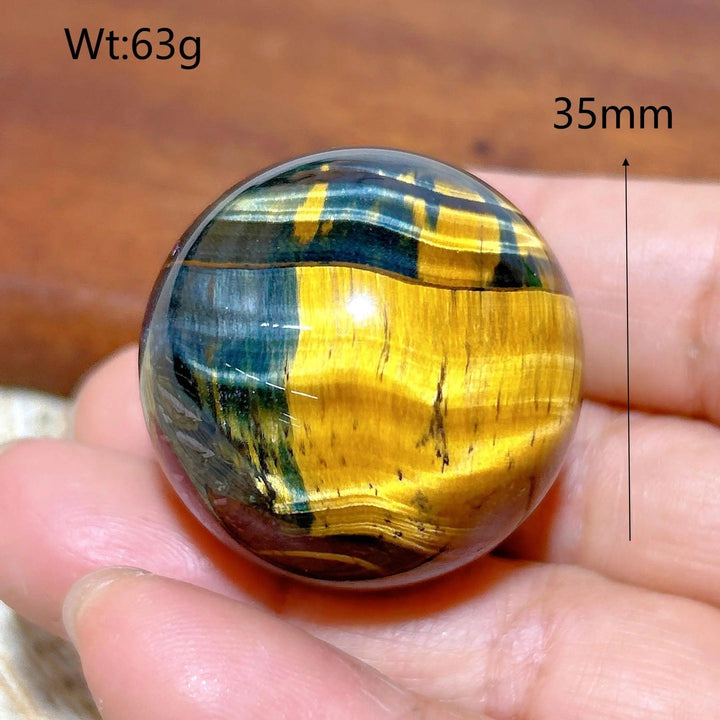 35mm Blue and Yellow Tiger Eye crystal sphere, a polished healing stone with flashy, vibrant energy for home decor.