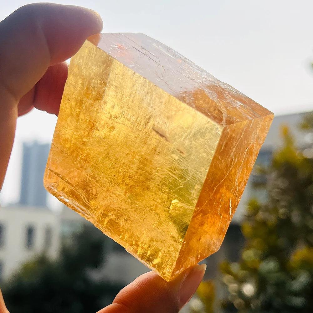 Hand holding a radiant, golden Honey Calcite natural raw crystal cluster, enhancing confidence and clarity.