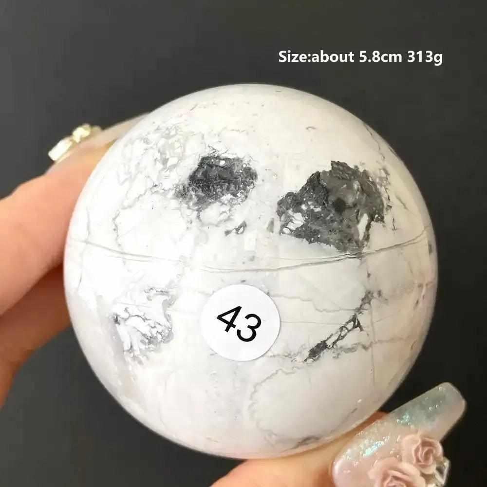 Polished Howlite sphere 43, a creamy white calming stone with gray veining and bold inclusions for Crown Chakra balance.