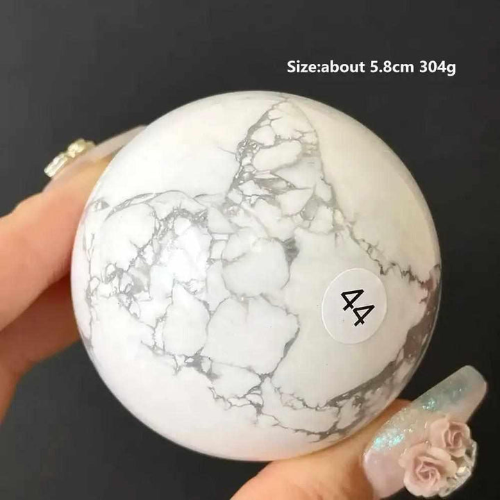 Polished 5.8cm Howlite sphere, style 44, featuring creamy white stone with delicate gray veining for Crown Chakra balance.
