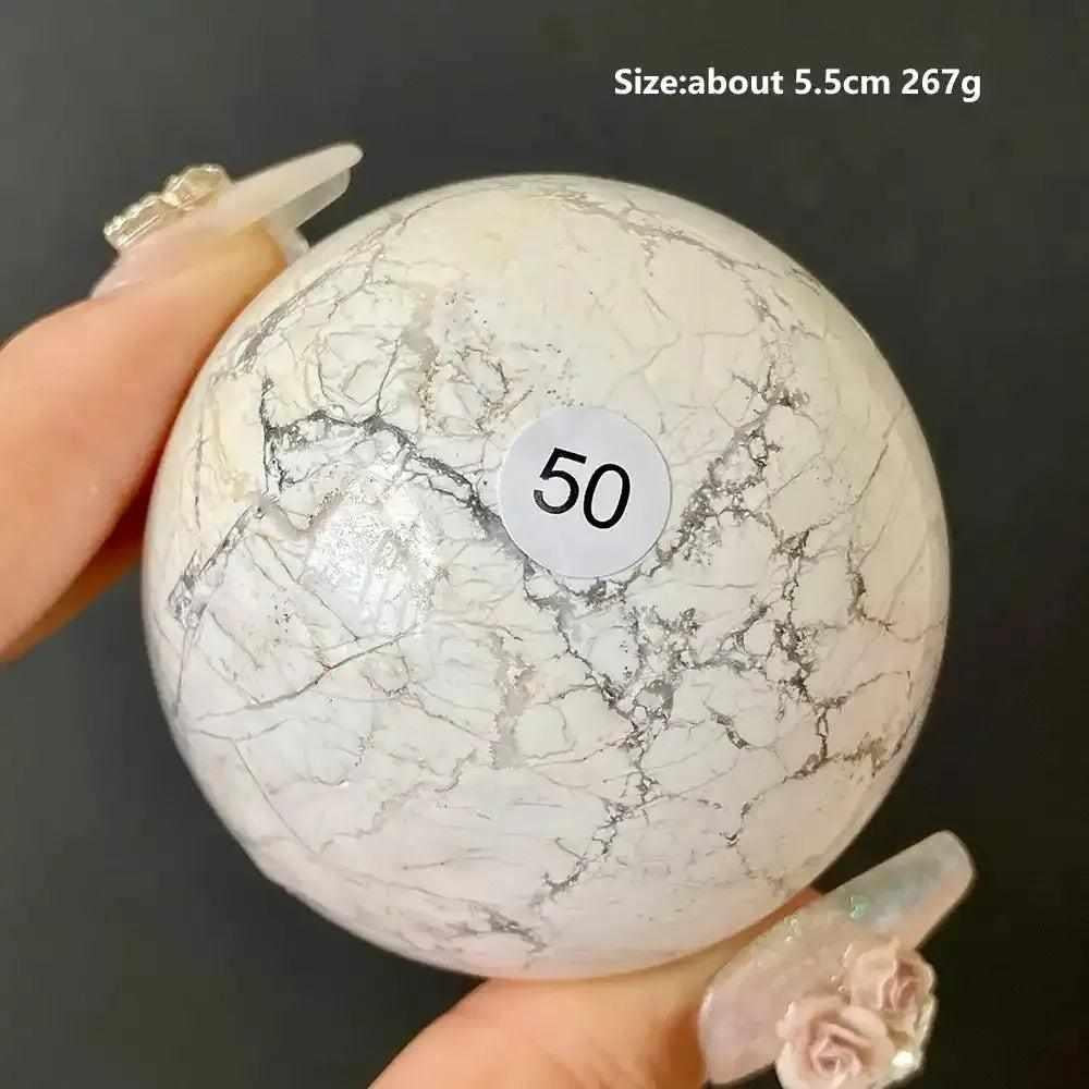 Polished 5.5cm Howlite sphere number 50, featuring creamy white stone with delicate gray veining for calm and balance.