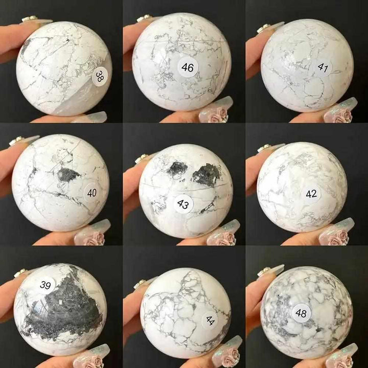 Polished Howlite spheres in creamy white with gray veining, numbered for selection to promote calm and Crown Chakra balance.
