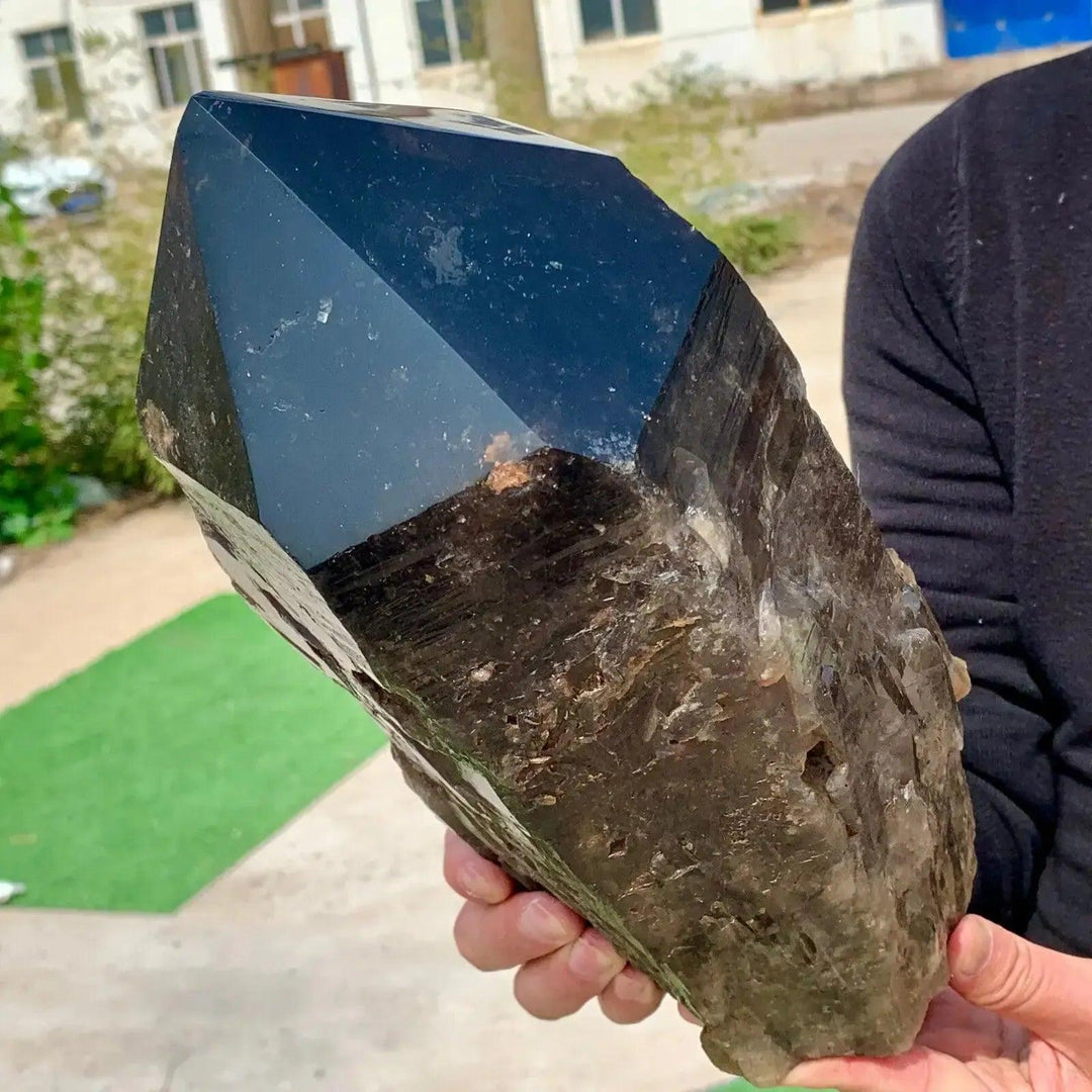 Huge, dark smoky-black natural Black Quartz crystal point, held by hand. Powerful grounding stone from Crystal Destiny.
