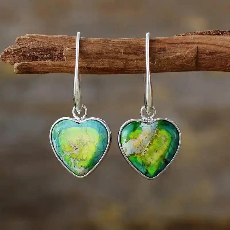 Vibrant green and yellow heart-shaped drop earrings with silver-plated accents, promoting balance and spiritual well-being.