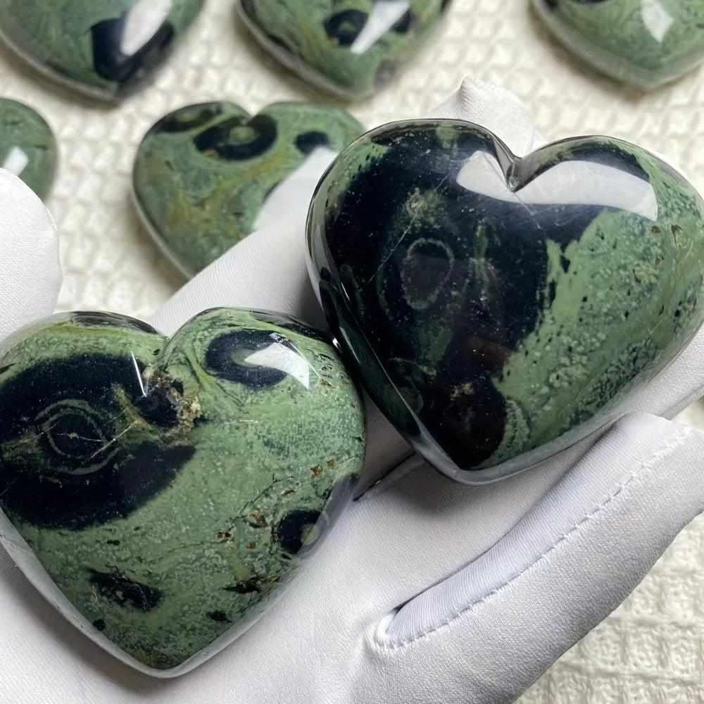 Polished Kambaba Jasper heart featuring deep green and black orb patterns for grounding and heart chakra healing.